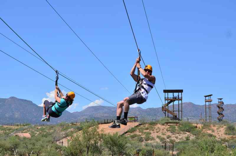 A man and a woman zip lining simultaneously