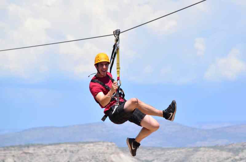 A man pretending to run through the air while zip lining